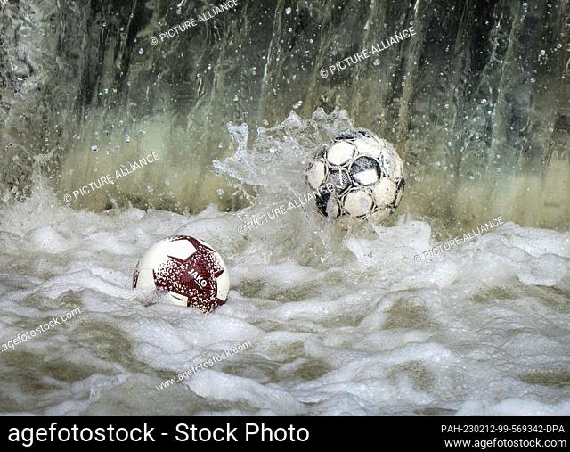 20 April 2021, Hesse, Frankfurt/Main: Footballs dance on the water at a weir on the Nidda River, where they are caught in the water's undertow