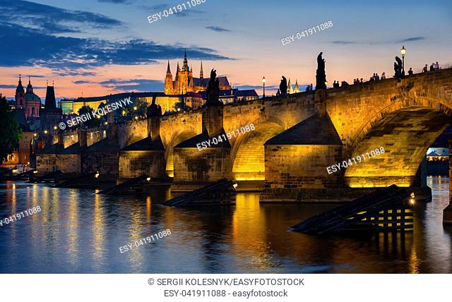 Sunset over illuminated Charles bridge in Prague