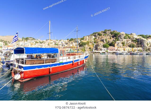 Brightly coloured boat moored in Gialos harbour, Symi Island, Dodecanese, Greece