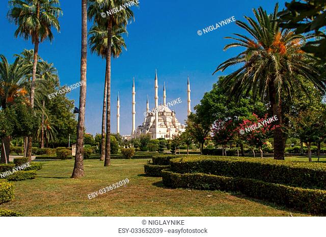 Exterior front view of Adana Sabanci Mosque, with six minarets, on bright blue sky background