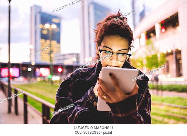 Woman in urban area using digital tablet, Milan, Italy