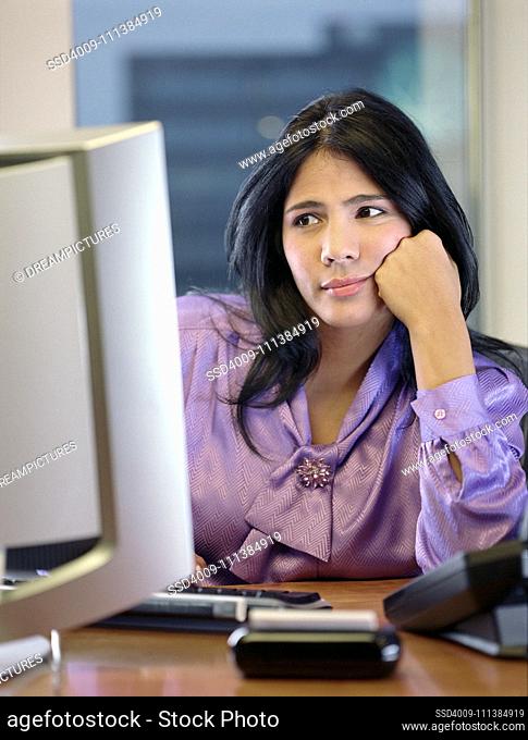 Hispanic businesswoman looking at computer