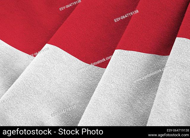 Indonesia flag with big folds waving close up under the studio light indoors. The official symbols and colors in fabric banner