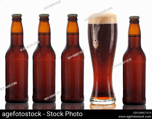 Four Brown Beer Bottles and a Full Glass with foam dripping down the side on a white background
