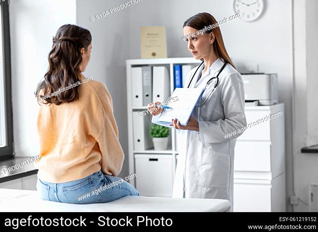 doctor showing cardiogram to woman at hospital