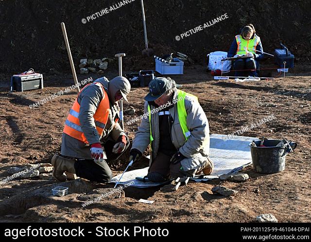 25 November 2020, Thuringia, Oberwellenborn: Excavation participants uncover finds for the Thuringian State Office for Monument Preservation and Archaeology...