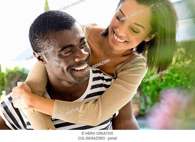 Young woman with arms around young man
