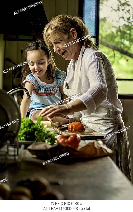 Grandmother and granddaughter preparing food