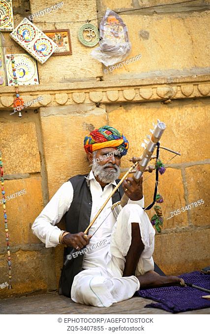 JAISALMER, RAJASTHAN, INDIA, November 2018, Local artist in traditional costume playing traditional musical instrument