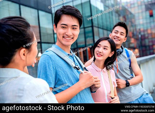 Outdoor four college students chatting together