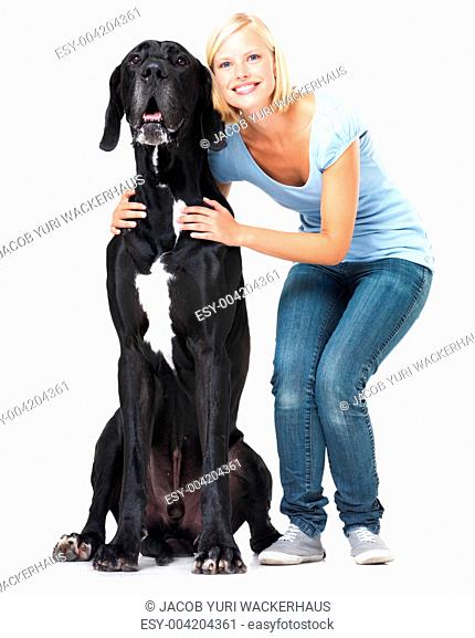 Cute young woman standing alongside her great dane with a smile - isolated on white