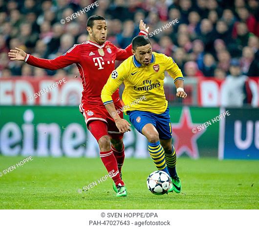Munich's Thiago Alcantara (R) and Alex Oxlade-Chamberlain of Arsenal vie for the ball during the UEFA Champions League round of 16 second leg soccer match...
