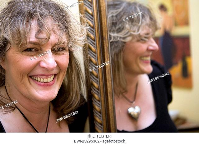 about 50 years old woman in front of a mirror