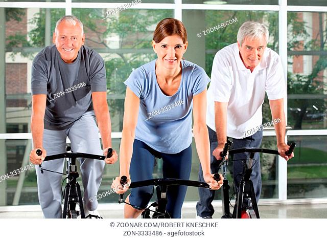 Senioren-Kurs im Fitnesscenter macht Spinning-Übungen
