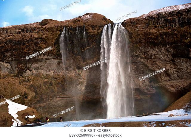 Tourists visit the waterfall Seljalandsfoss in Iceland