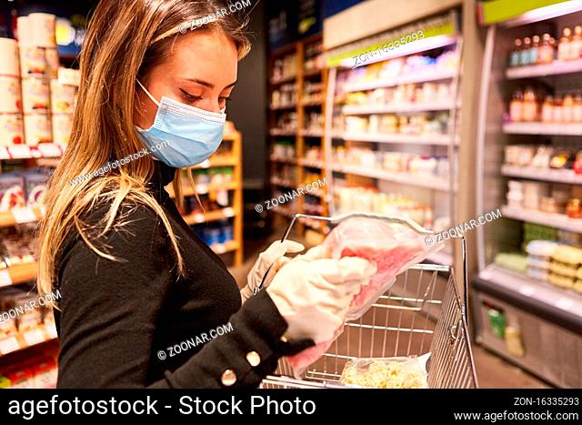 Kundin mit Mundschutz und Latexhandschuhen beim Lebensmittel Kauf im Supermarkt