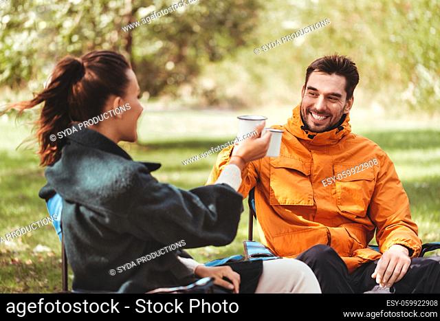 happy couple drinking tea at campsite