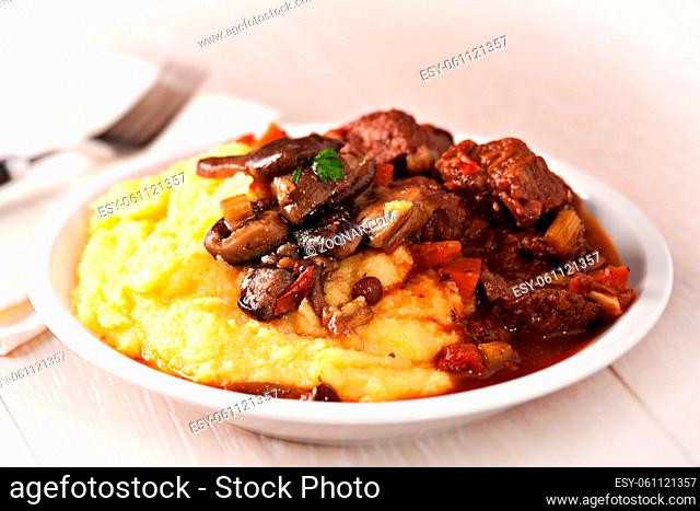 Delicious beef stew with mushrooms and polenta. High quality photo