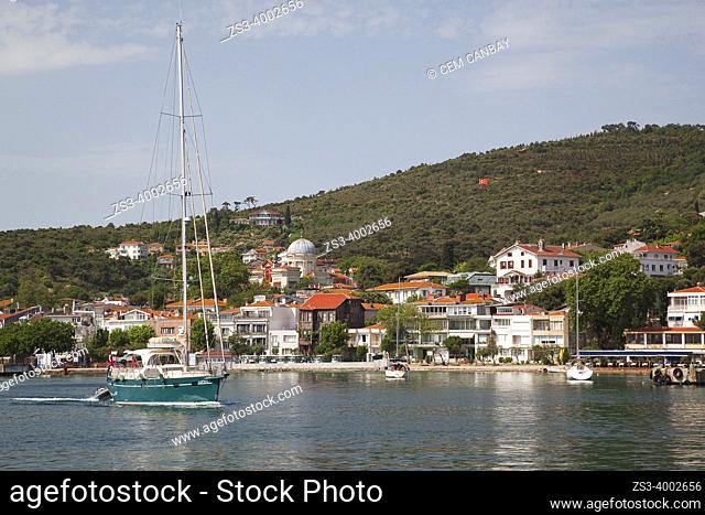 Sailing boat in front of the traditional wooden houses and restaurants in Burgazada island, ancient Antigoni, Princes' Islands, Istanbul, Marmara Region, Turkey