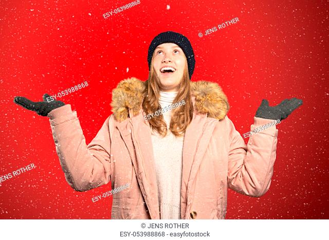 a woman catches snowflakes with her mouth and tongue