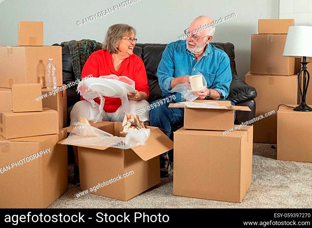 Senior Adult Couple Packing or Unpacking Moving Boxes