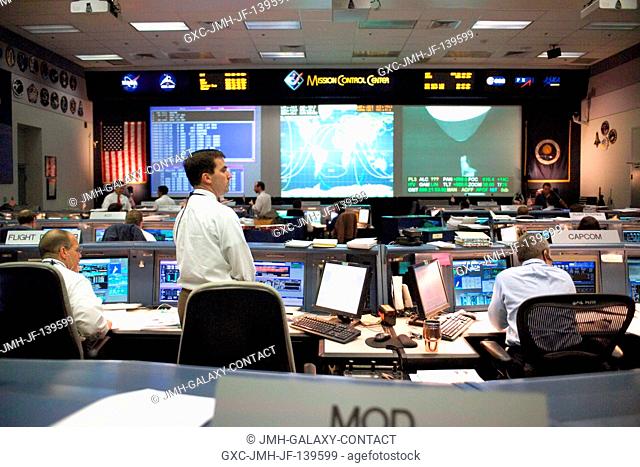 Flight Director Paul Hill queries the neighboring CAPCOM console during a long-duration return to flight integrated simulation in this wide view of the Shuttle...