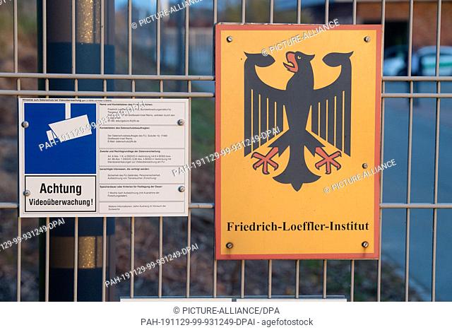 13 November 2019, Mecklenburg-Western Pomerania, Insel Riems: A sign with a federal eagle hangs in the entrance area of the Friedrich-Loeffler-Institute for...