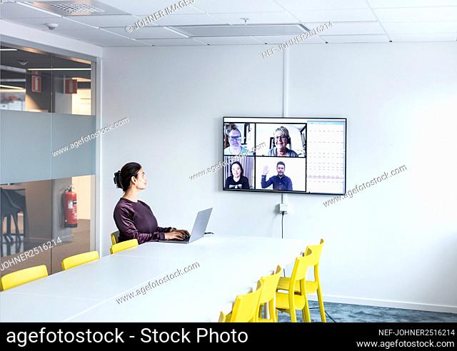 Woman having video conference in boardroom