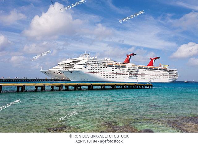 Cruise ship passengers on pier disembarking from Carnival cruise ships Triumph and Ecstasy in Cozumel, Mexico in the Caribbean Sea