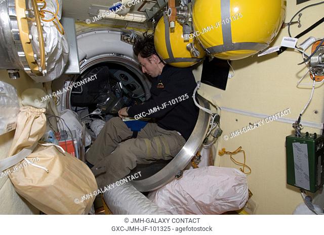 Russian cosmonaut Sergei Revin, Expedition 32 flight engineer, works near a hatch on the International Space Station