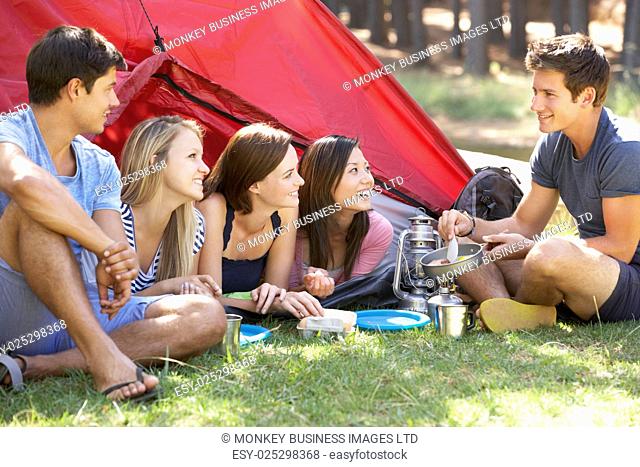 Group Of Young People Cooking Breakfast On Camping Holiday