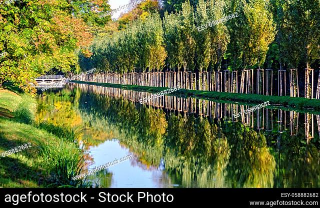 Kanal mit Alleebäumen im Schlosspark von Laxenburg an einem sonnigen Herbsttag, Österreich; canal with alley trees on a sunny day in autumn in the palace park...