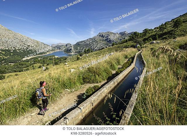escursionista andando junto a la canal de transvase del Gorg Blau - Cúber, Escorca, Paraje natural de la Serra de Tramuntana, Mallorca, balearic islands, Spain