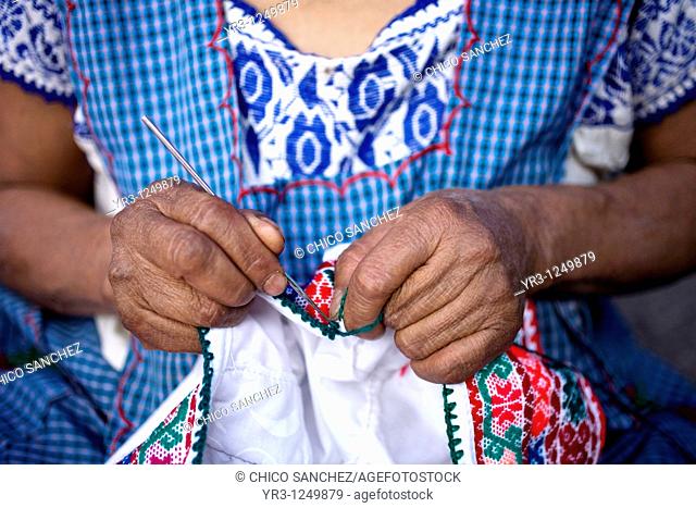 A woman stitches a design on the top of a blouse in Cuetzalan del Progreso, Mexico. Cuetzalan is a small picturesque market town nestled in the hills of...