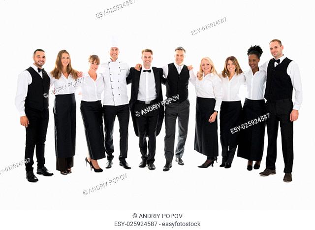 Full length portrait of confident restaurant staff standing with arms around against white background