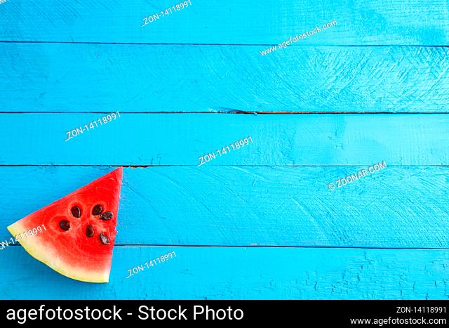 red scarlet watermelon pieces on blue wooden vintage background. summer concept. the view from the top