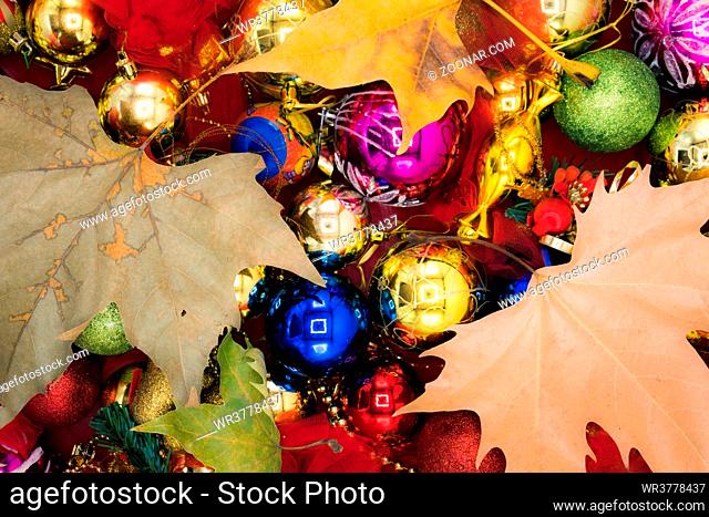 Christmas vibrant colorful wallpaper background texture of balls and decorations for the celebration tree and dry leaves