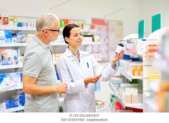medicine, pharmaceutics, health care and people concept - happy pharmacist and senior man customer with drug and prescription at drugstore