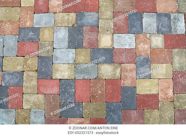 Background of street road colorful stone paving of multicolor bricks, close up, top view, high angle, directly above