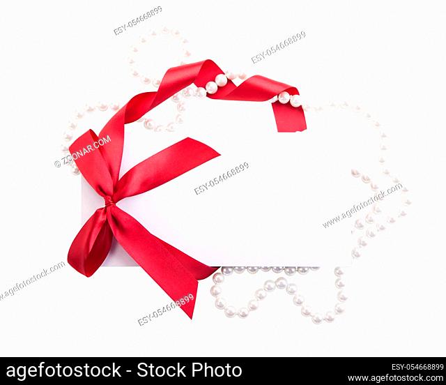 Close up of card note with red ribbon isolated on white background