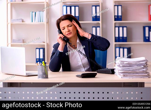 Middle-aged female employee suffering in the office