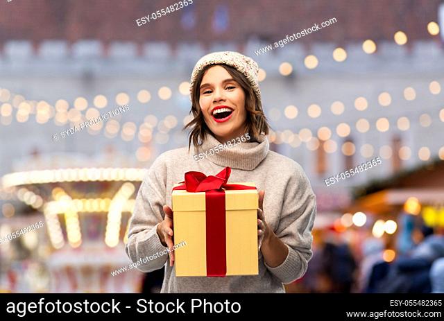 happy young woman in hat holding chrismas gift