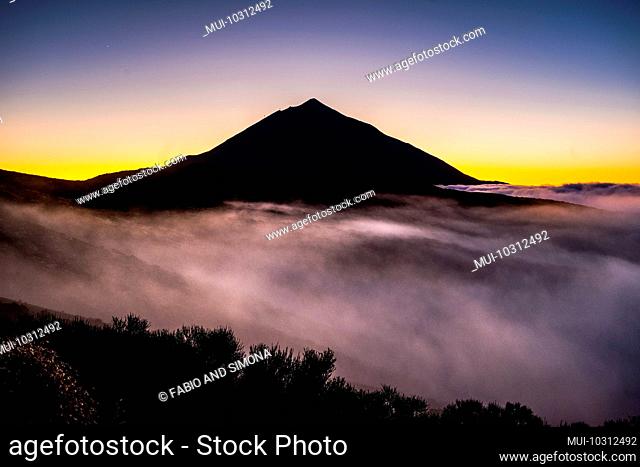 Beautiful el teide tenerife vulcan landscape with high top and clouds in the ground like mist fog - timeless and national park scenic outdoor place - coloured...