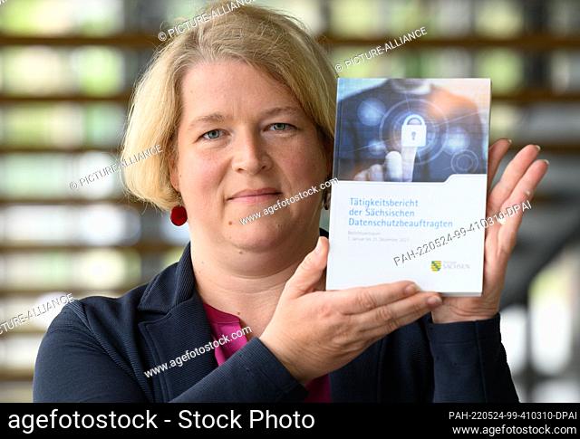 24 May 2022, Saxony, Dresden: Juliane Hundert, data protection commissioner in Saxony, holds the activity report for 2021 in her hands before the start of the...