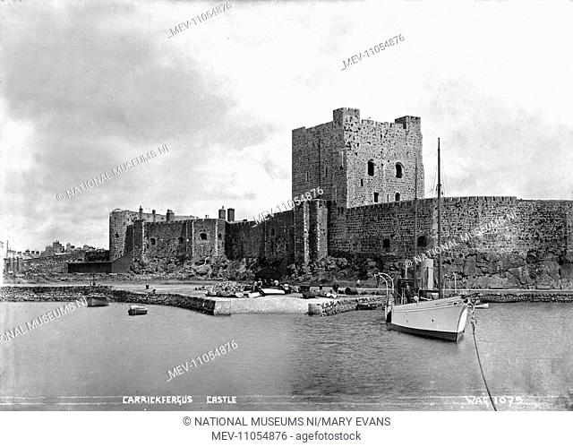 Carrickfergus Castle - with a boat in the foreground and people visible on the slipway. (Location: Northern Ireland: County Antrim: Carrickfergus)