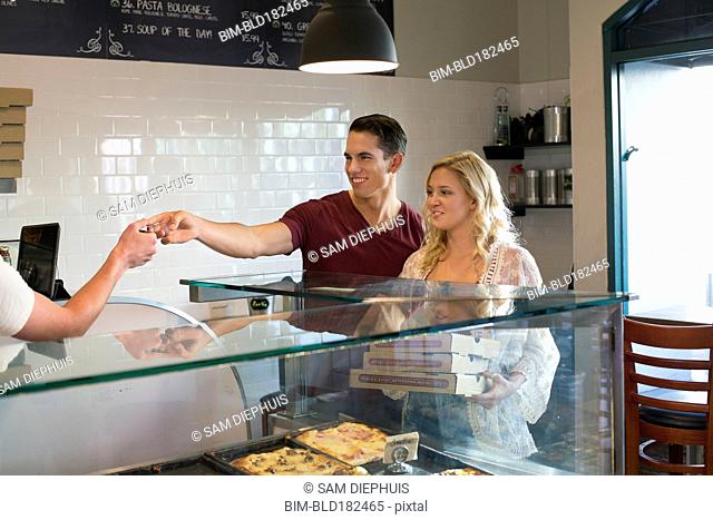Customers purchasing pizza in cafe