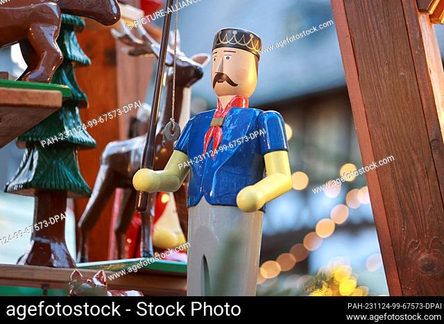 24 November 2023, Saxony-Anhalt, Wernigerode: A wooden figure turns on a Christmas pyramid on the market square in Wernigerode