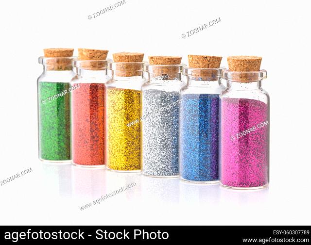 Row of colorful glitter powder bottles isolated on white
