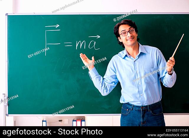 Young male physic standing in front of the green board