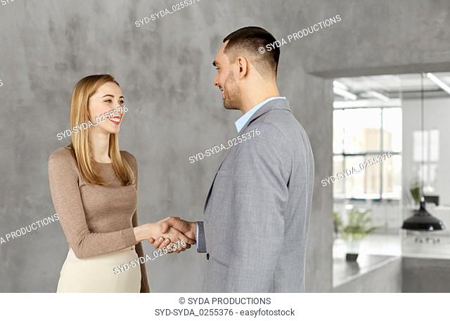 smiling businesswoman and businessman at office